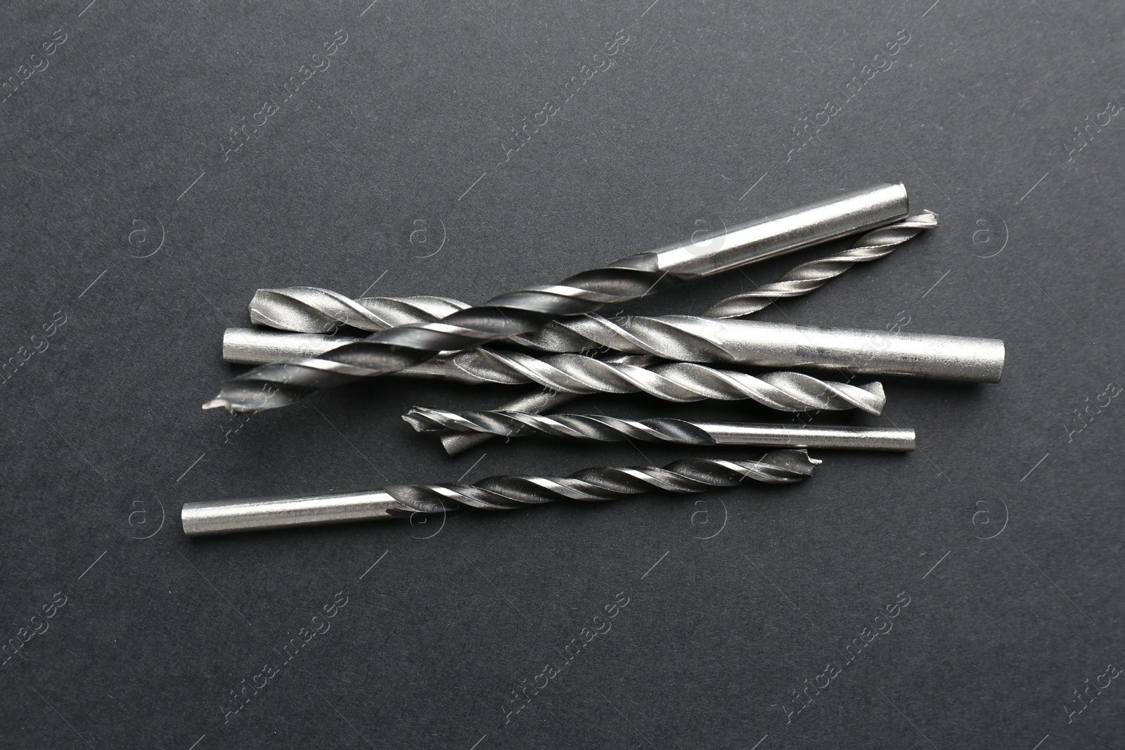 Photo of Many different drill bits on grey table, top view