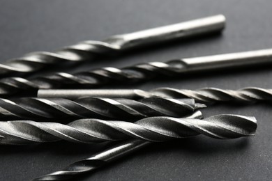 Many different drill bits on grey table, closeup