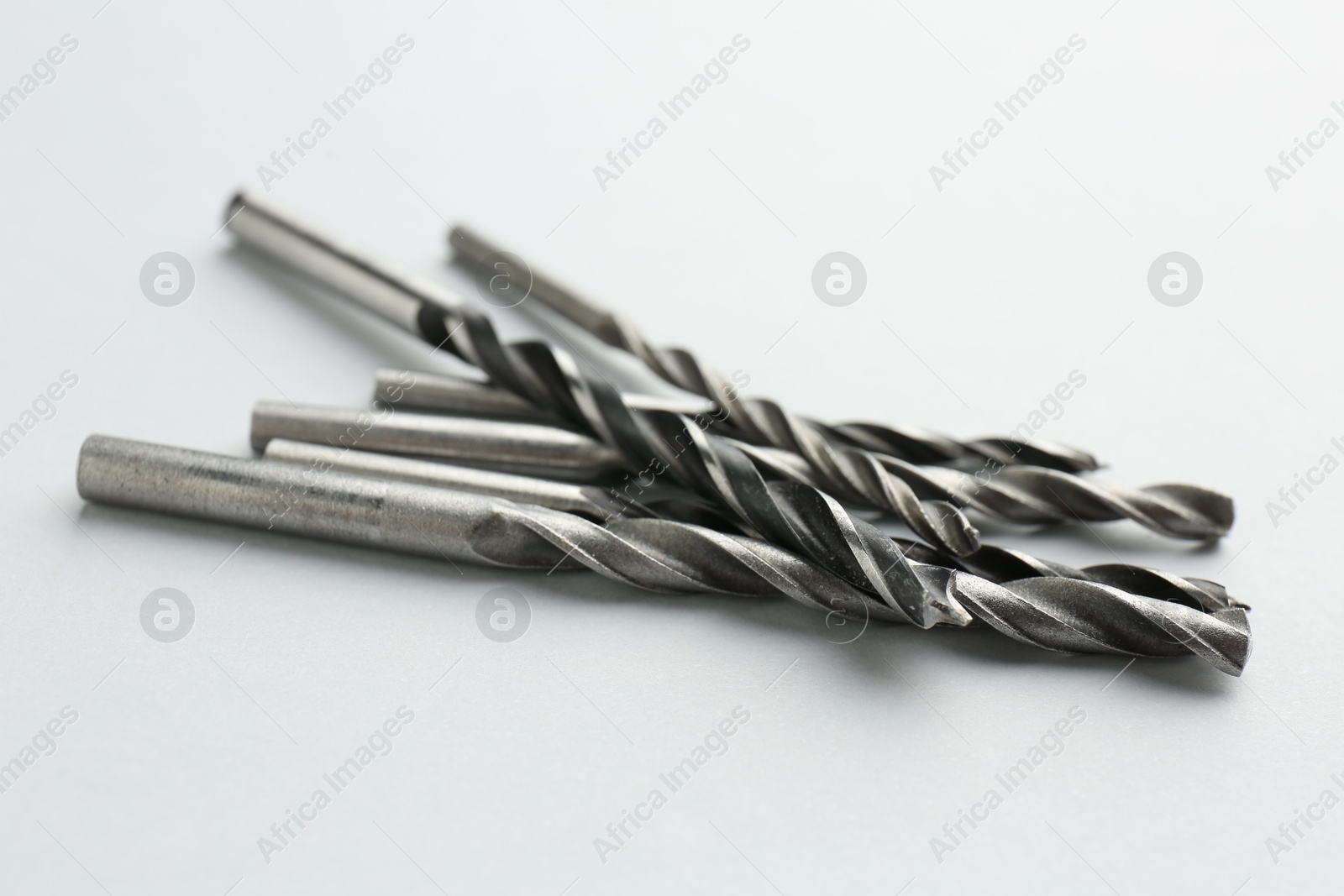 Photo of Many different drill bits on light grey background