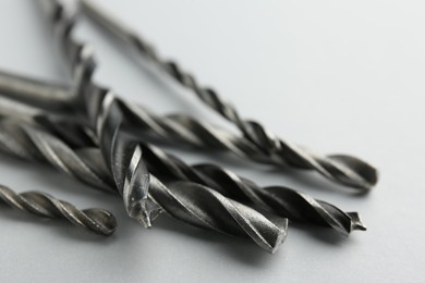 Many different drill bits on light grey background, closeup