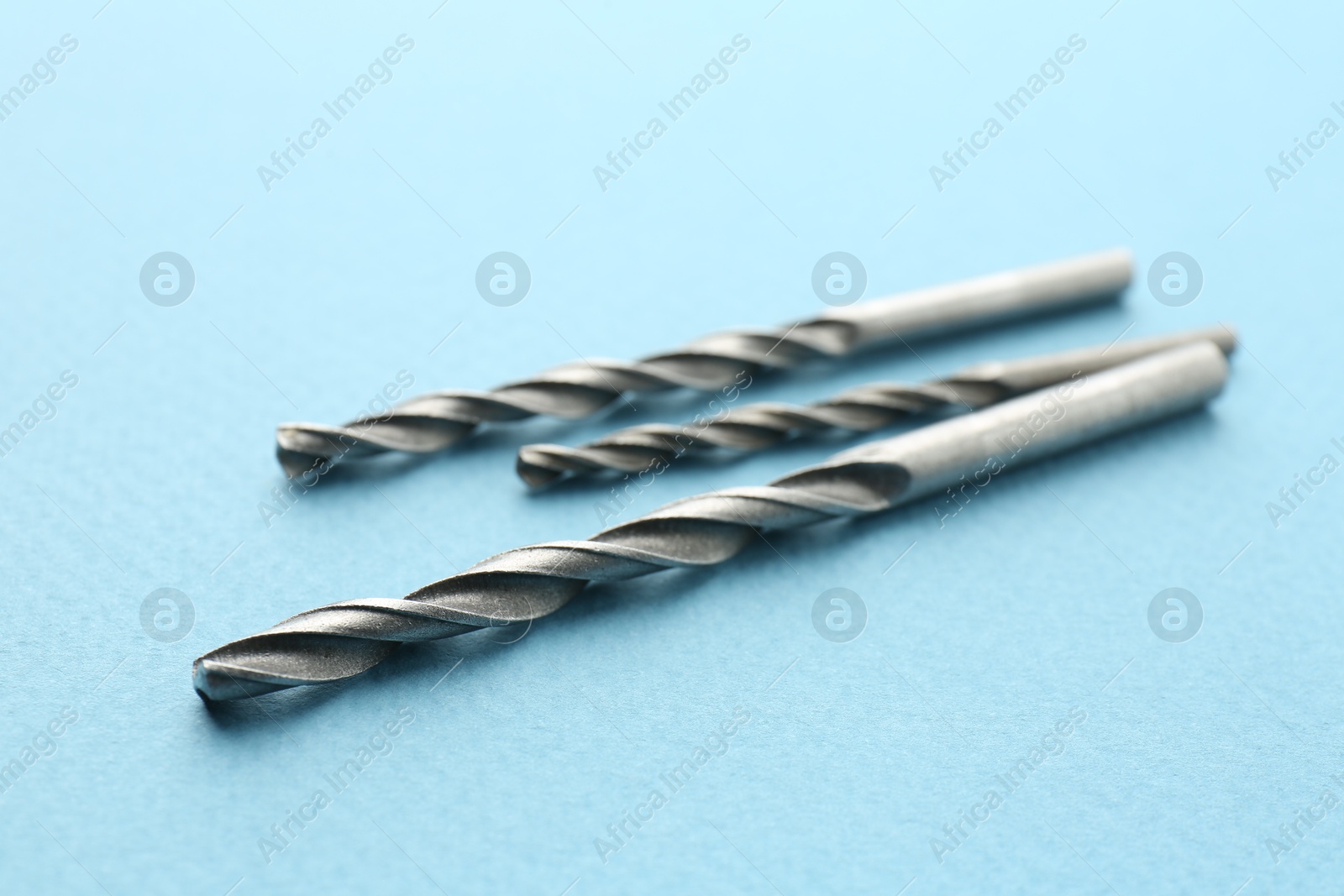 Photo of Different drill bits on light blue background