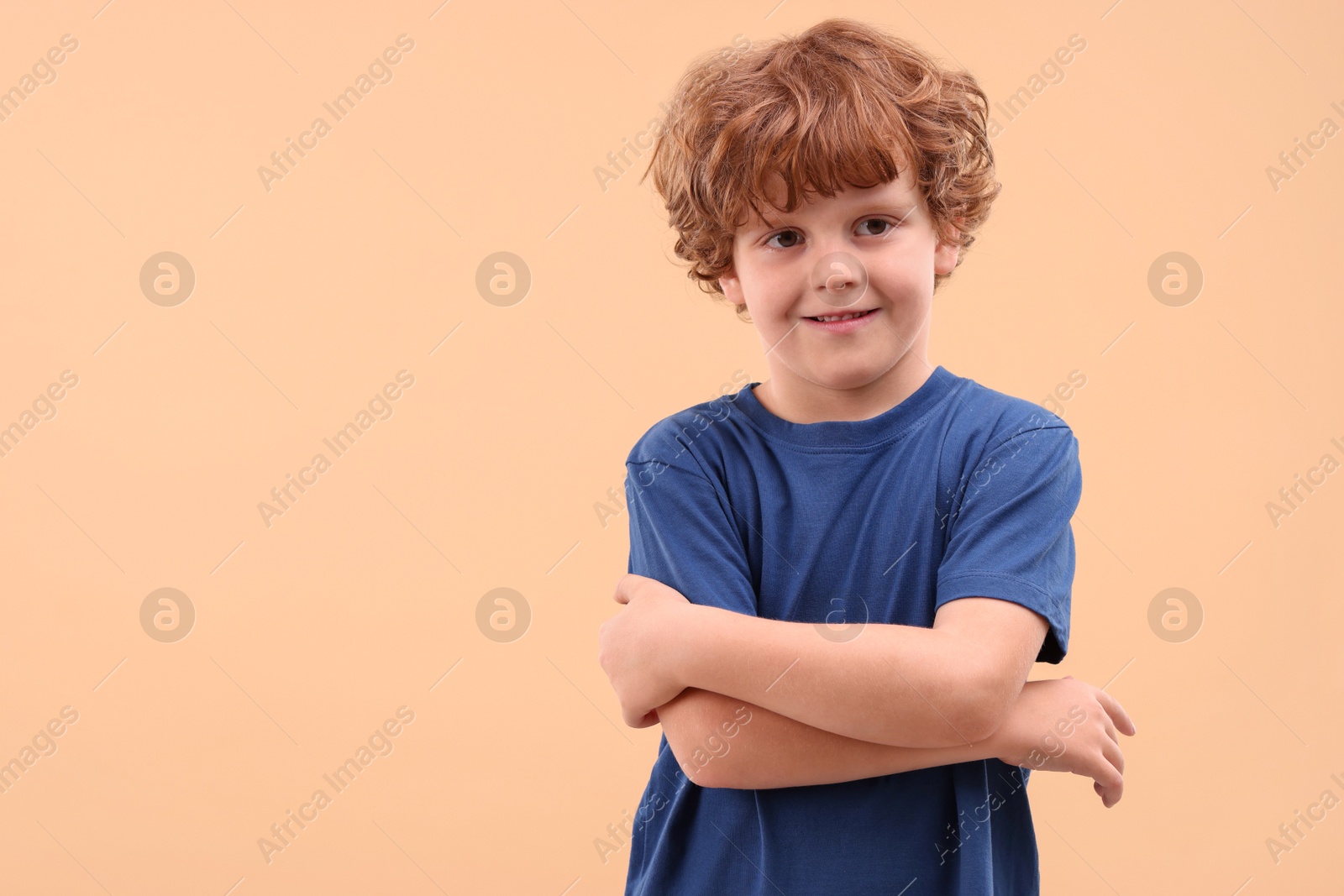 Photo of Portrait of cute little boy on beige background, space for text