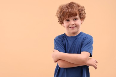 Photo of Portrait of cute little boy on beige background, space for text