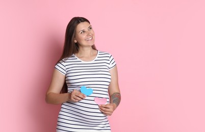 Photo of Beautiful pregnant woman with paper hearts on pink background, space for text. Expecting twins