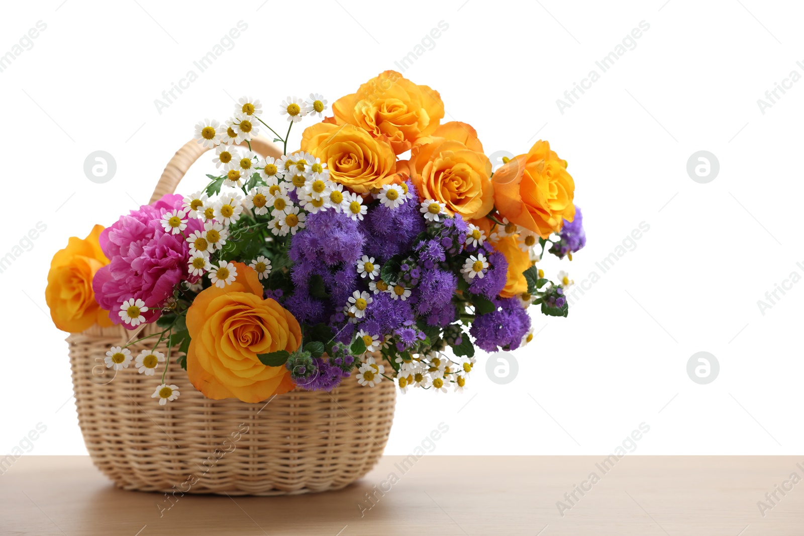 Photo of Wicker basket with beautiful flowers on wooden table against white background, space for text