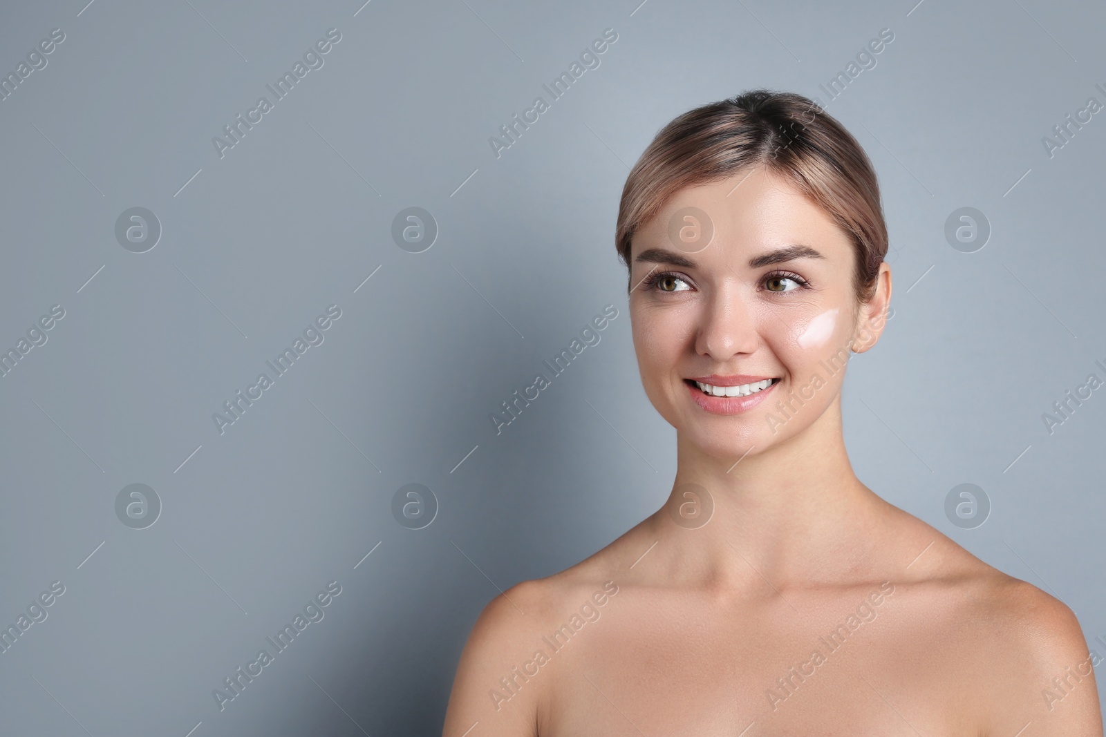 Photo of Beautiful woman with cream on her face against gray background, space for text