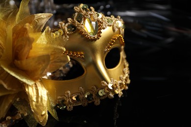 Beautiful golden carnival mask on black background, closeup. Space for text