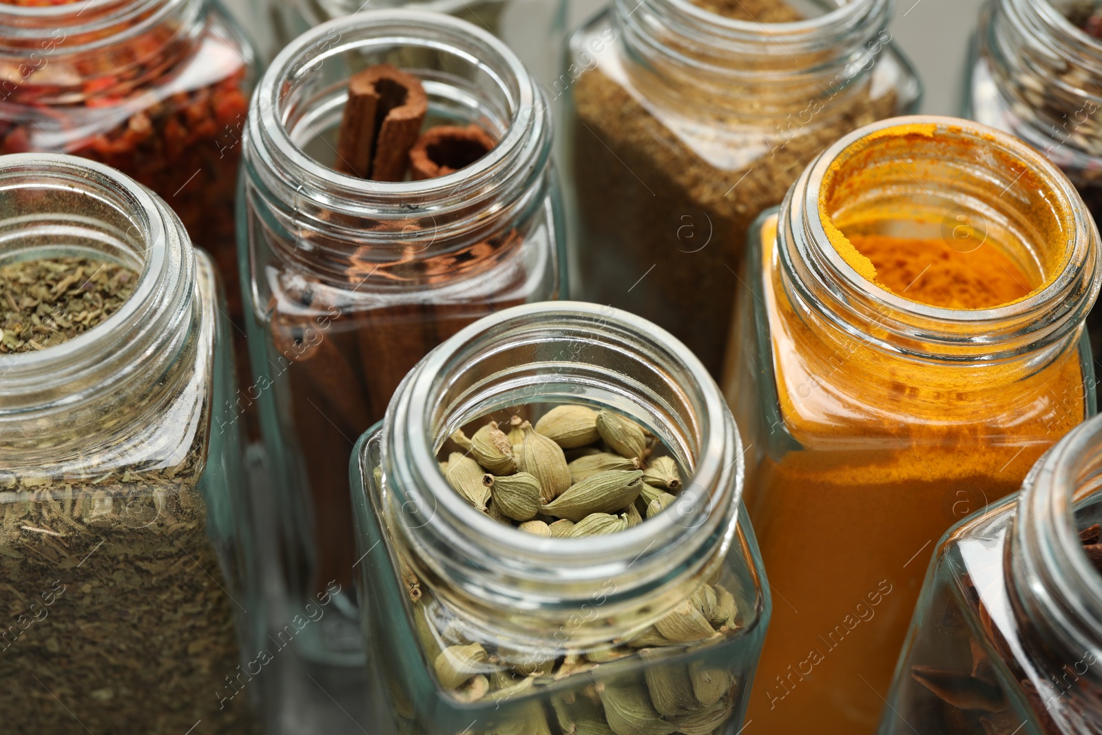 Photo of Different spices in glass jars on table, closeup