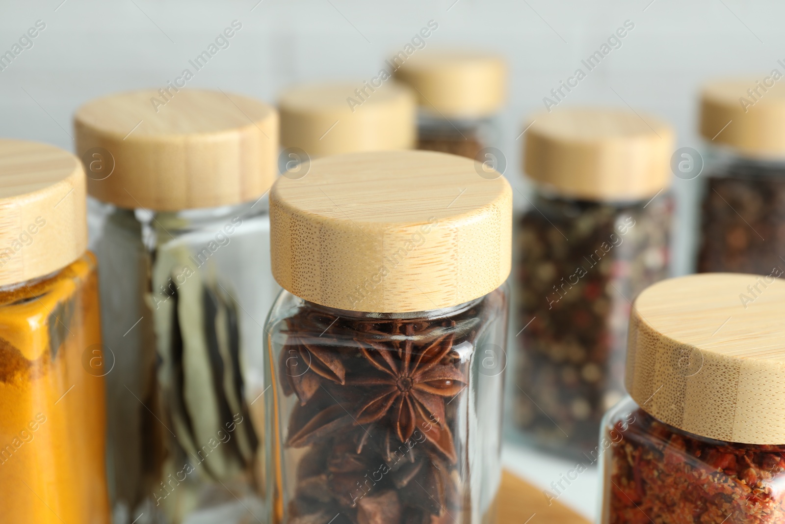 Photo of Different spices in glass jars on table, closeup