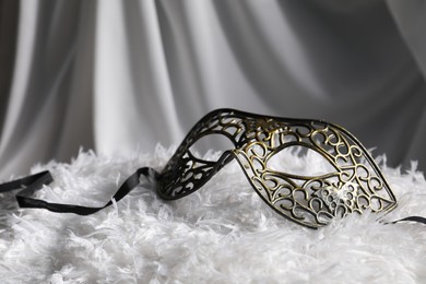 Beautiful carnival mask on white fabric, closeup