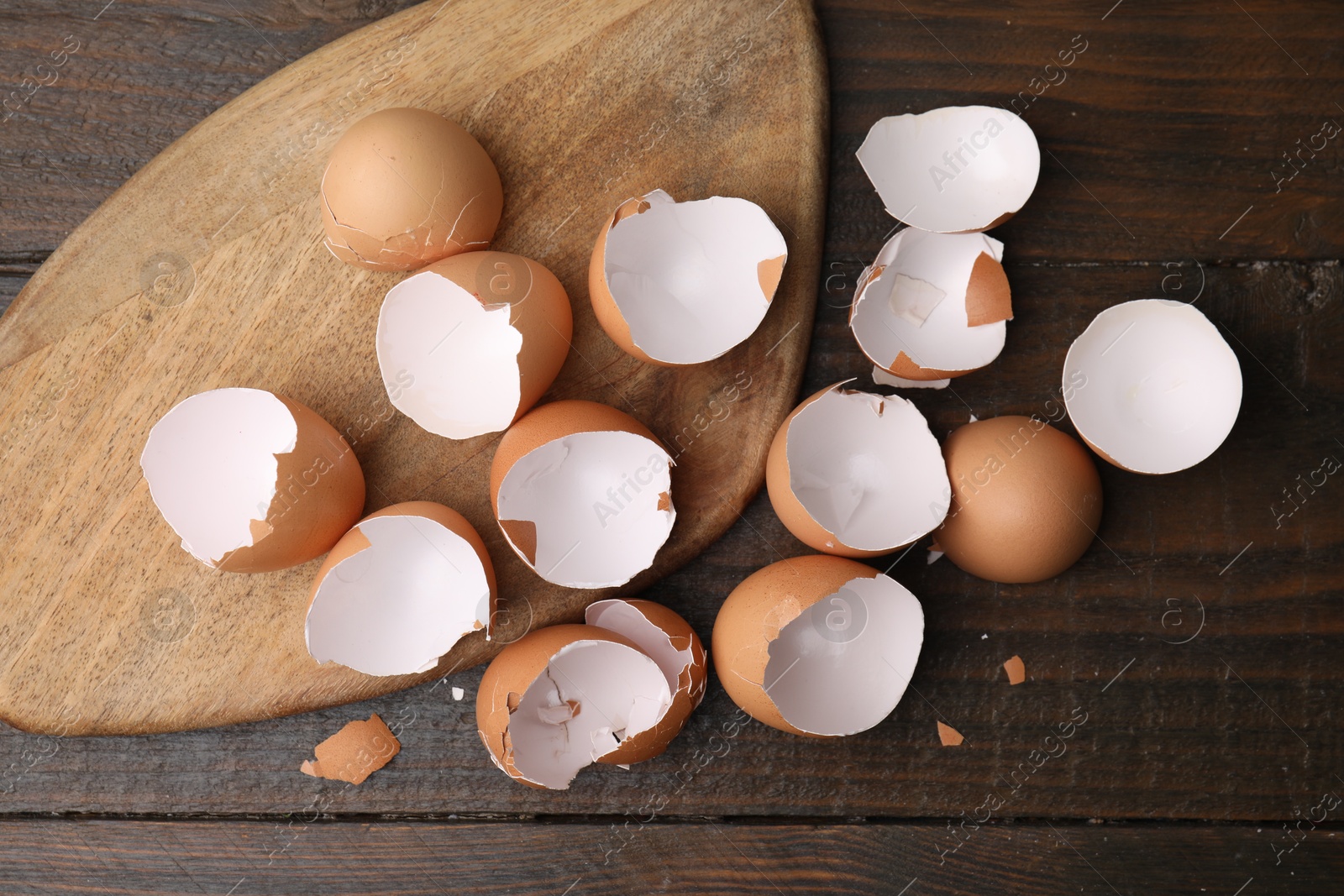 Photo of Broken eggshells on wooden table, top view