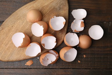 Photo of Broken eggshells on wooden table, top view