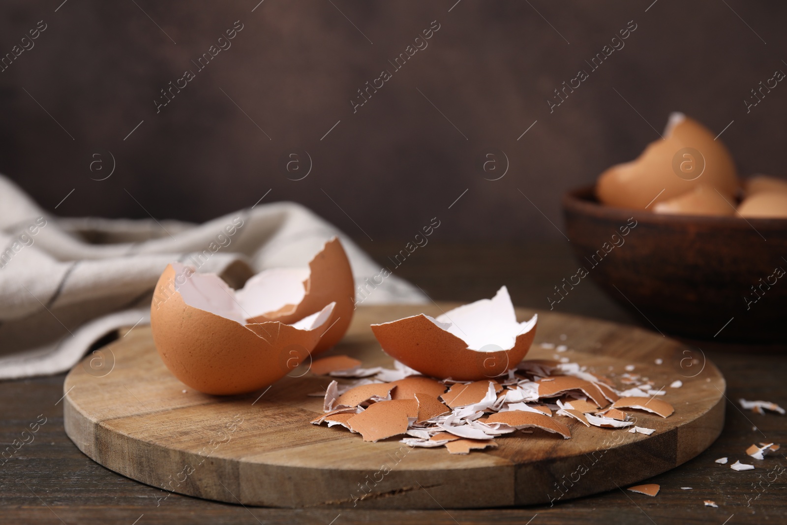 Photo of Pieces of broken eggshells on wooden table, closeup