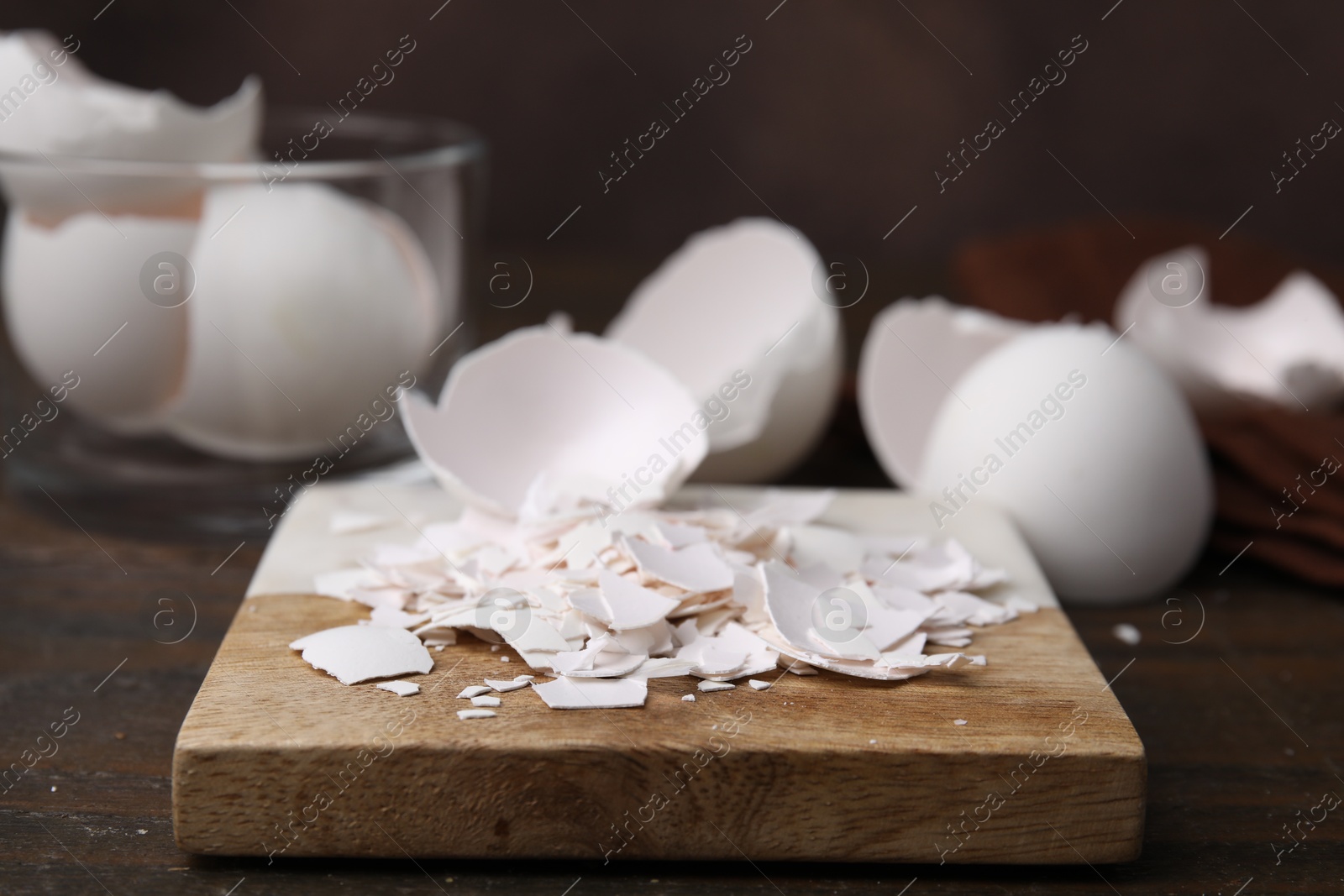 Photo of Pieces of broken eggshells on wooden table, closeup