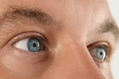 Photo of Man with beautiful blue eyes on white background, closeup