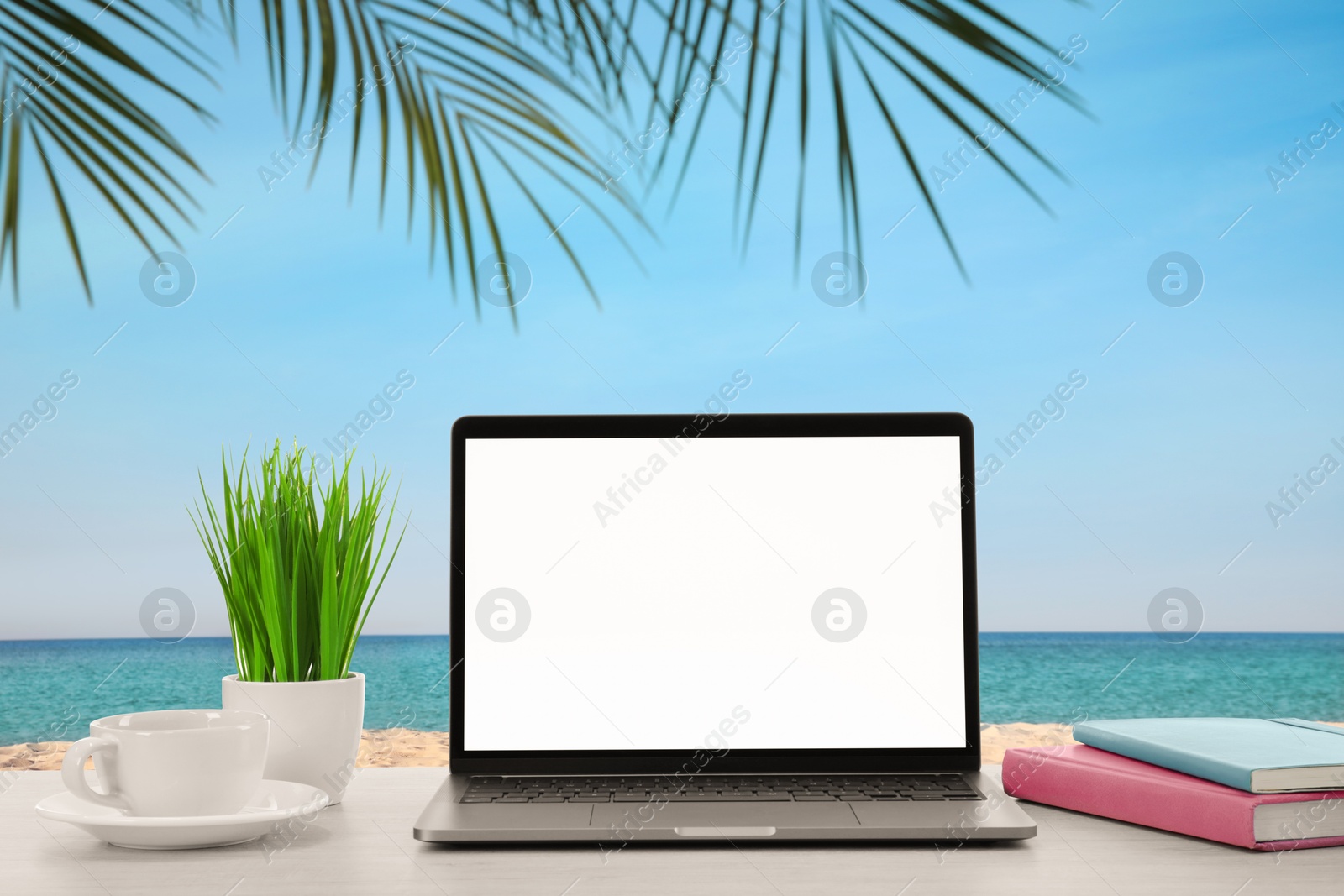 Image of Workplace at beach, distant office. Table with laptop on sandy seashore. Mockup for design