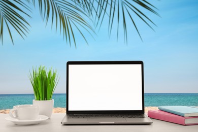 Image of Workplace at beach, distant office. Table with laptop on sandy seashore. Mockup for design