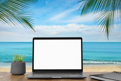 Image of Workplace at beach, distant office. Table with laptop on sandy seashore. Mockup for design