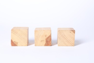 Photo of Three blank wooden cubes on white background