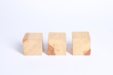 Photo of Three blank wooden cubes on white background