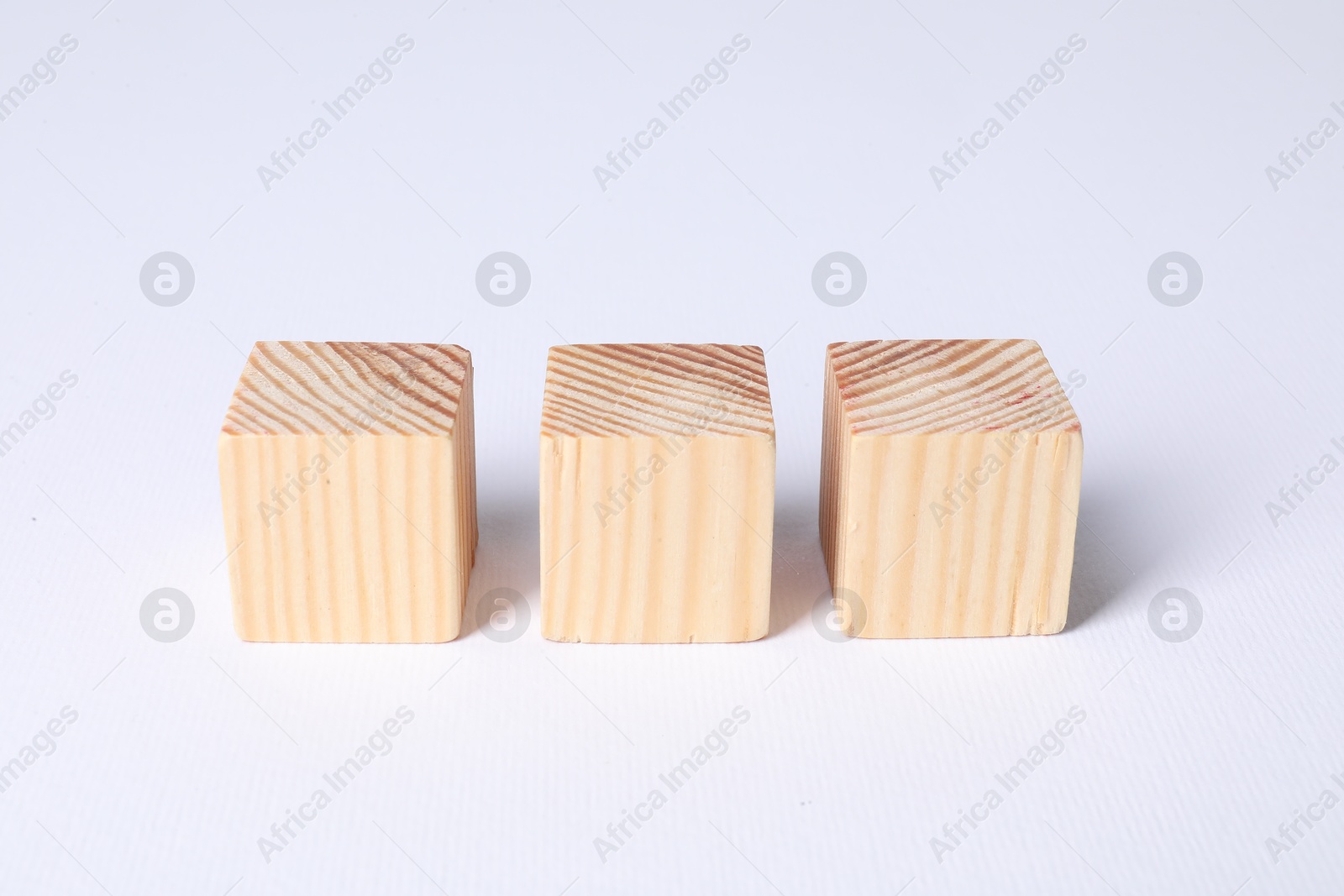 Photo of Three blank wooden cubes on white background