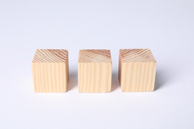 Three blank wooden cubes on white background