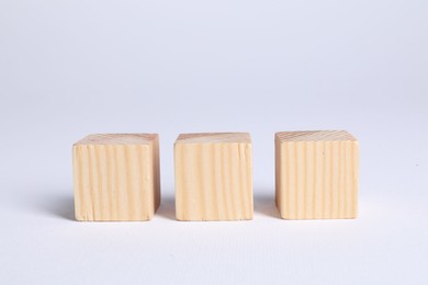 Photo of Three blank wooden cubes on white background