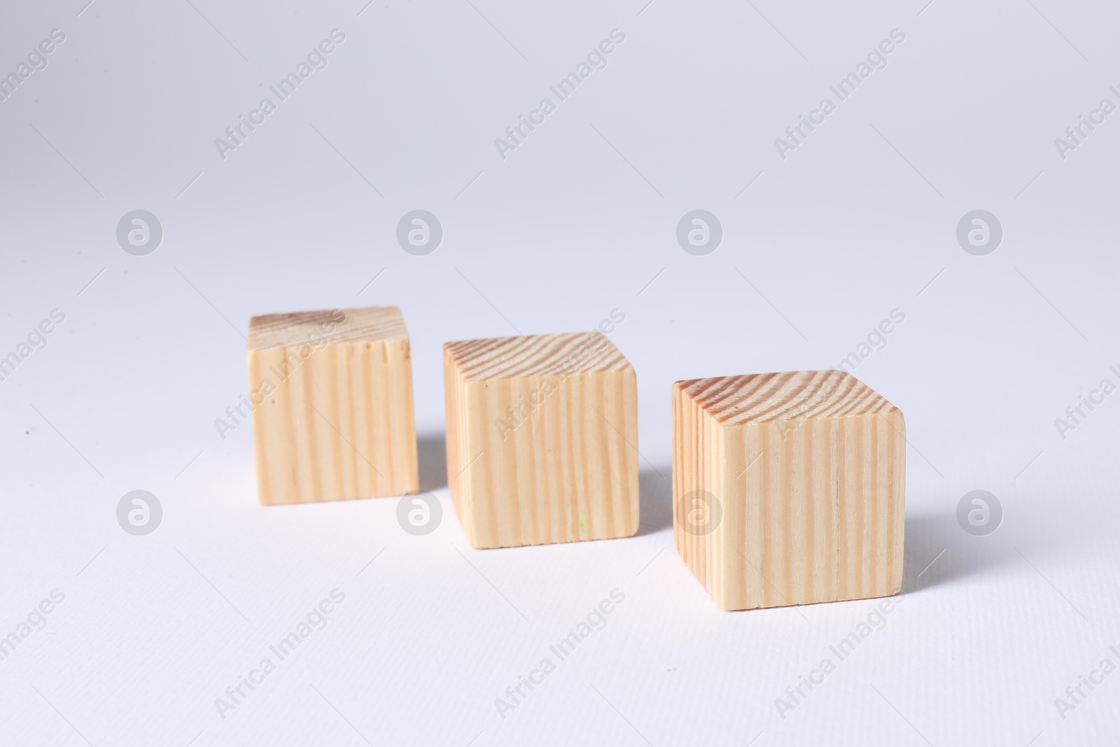 Photo of Three blank wooden cubes on white background