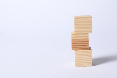 Photo of Three blank wooden cubes on white background, space for text