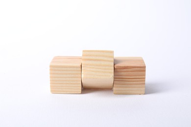 Photo of Three blank wooden cubes on white background