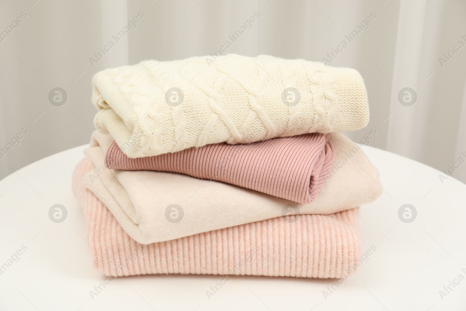 Photo of Stack of clothes on white table indoors