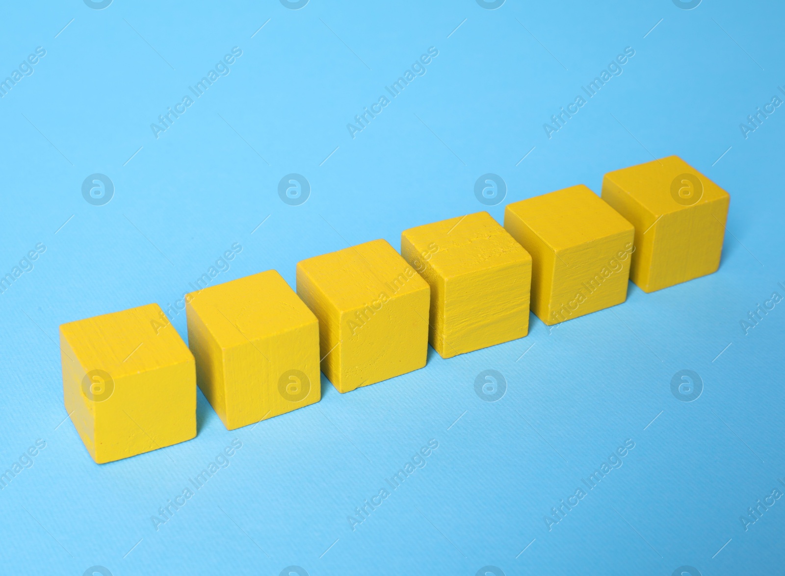 Photo of Blank yellow cubes on light blue background