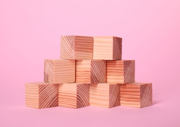 Photo of Many blank wooden cubes on pink background