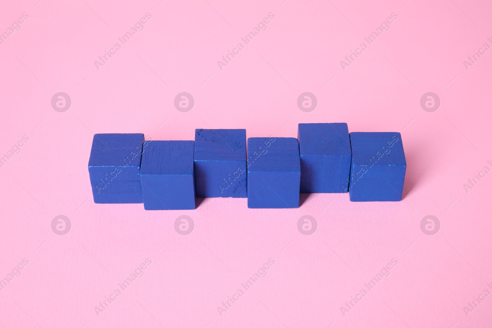 Photo of Many blank blue cubes on pink background