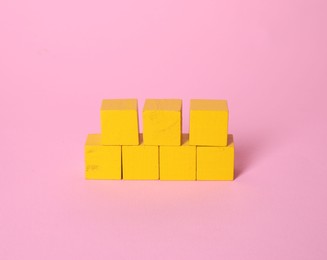 Photo of Many blank yellow cubes on pink background