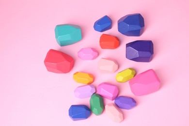 Photo of Many colorful balancing stones on pink background, top view