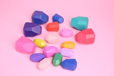 Photo of Many colorful balancing stones on pink background, above view