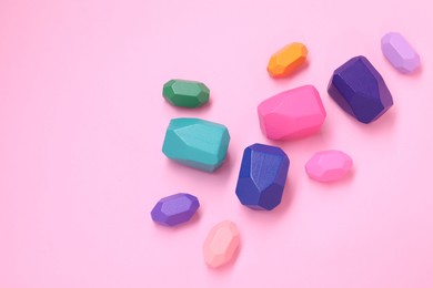 Photo of Many colorful balancing stones on pink background, top view. Space for text