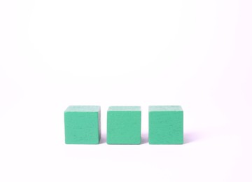 Photo of Three blank green cubes on white background