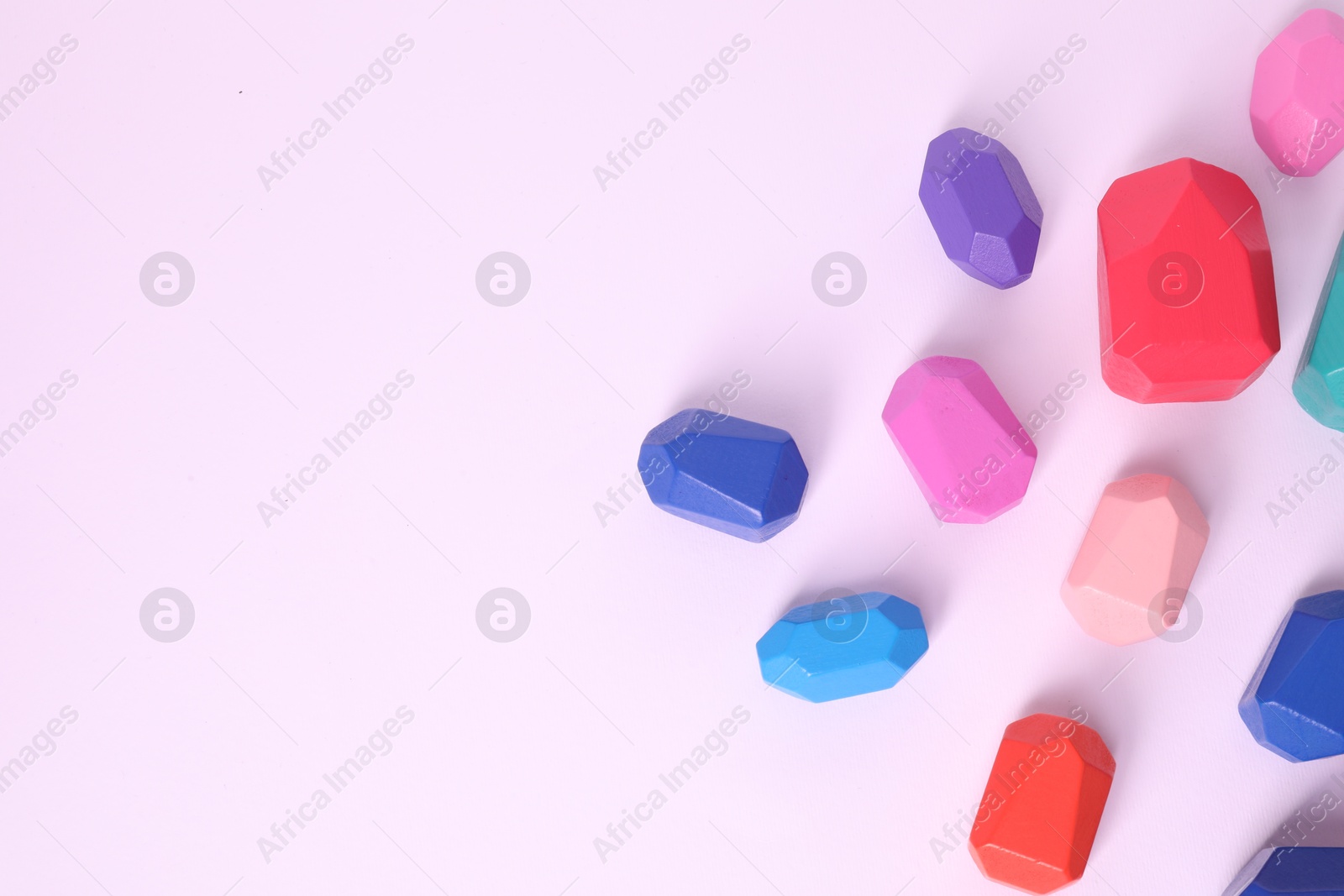 Photo of Many colorful balancing stones on white background, top view. Space for text