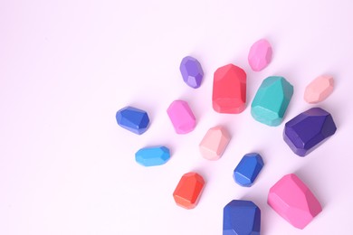 Photo of Many colorful balancing stones on white background, top view. Space for text