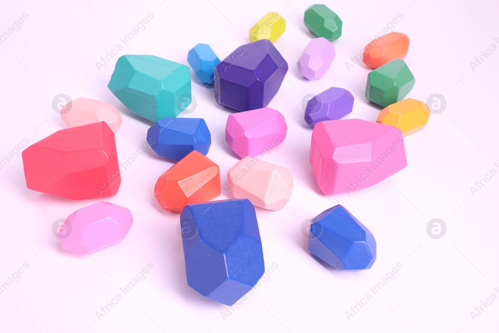 Photo of Many colorful balancing stones on white background