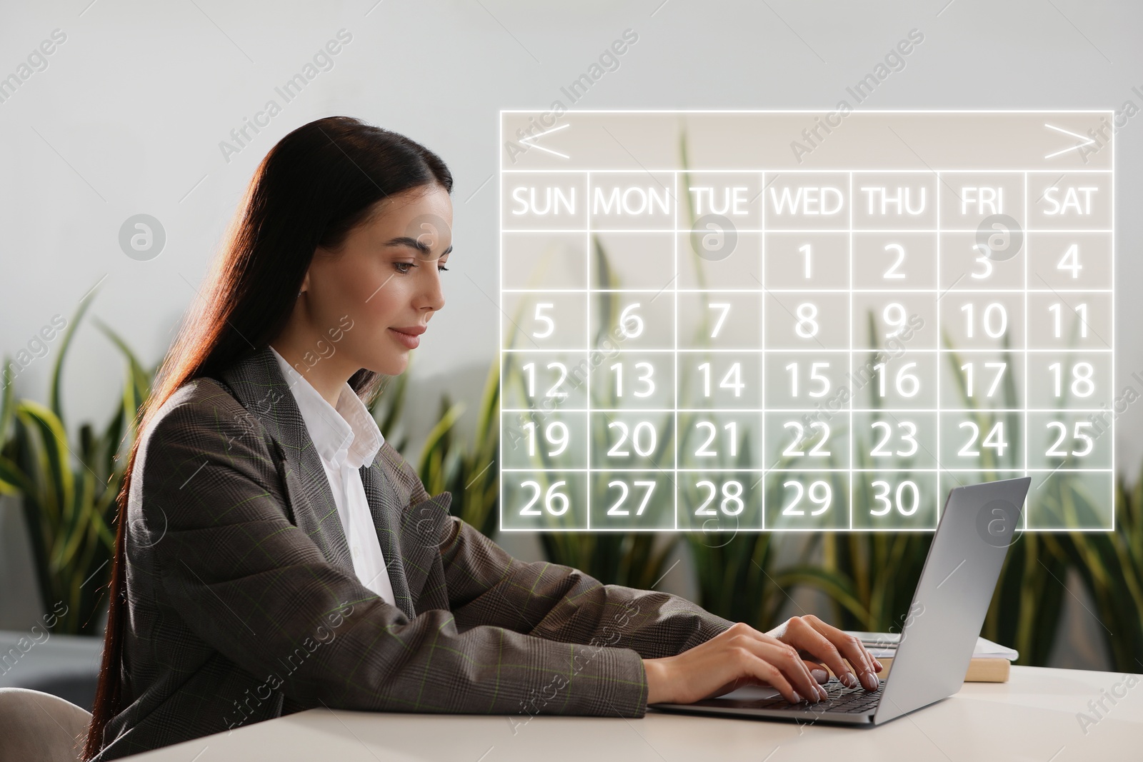 Image of Businesswoman making timetable in laptop at table. Virtual calendar near her