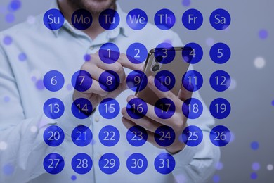 Image of Man making timetable in mobile phone at table. Virtual calendar in foreground