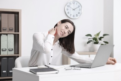 Image of Woman suffering from backache due to poor posture at workplace
