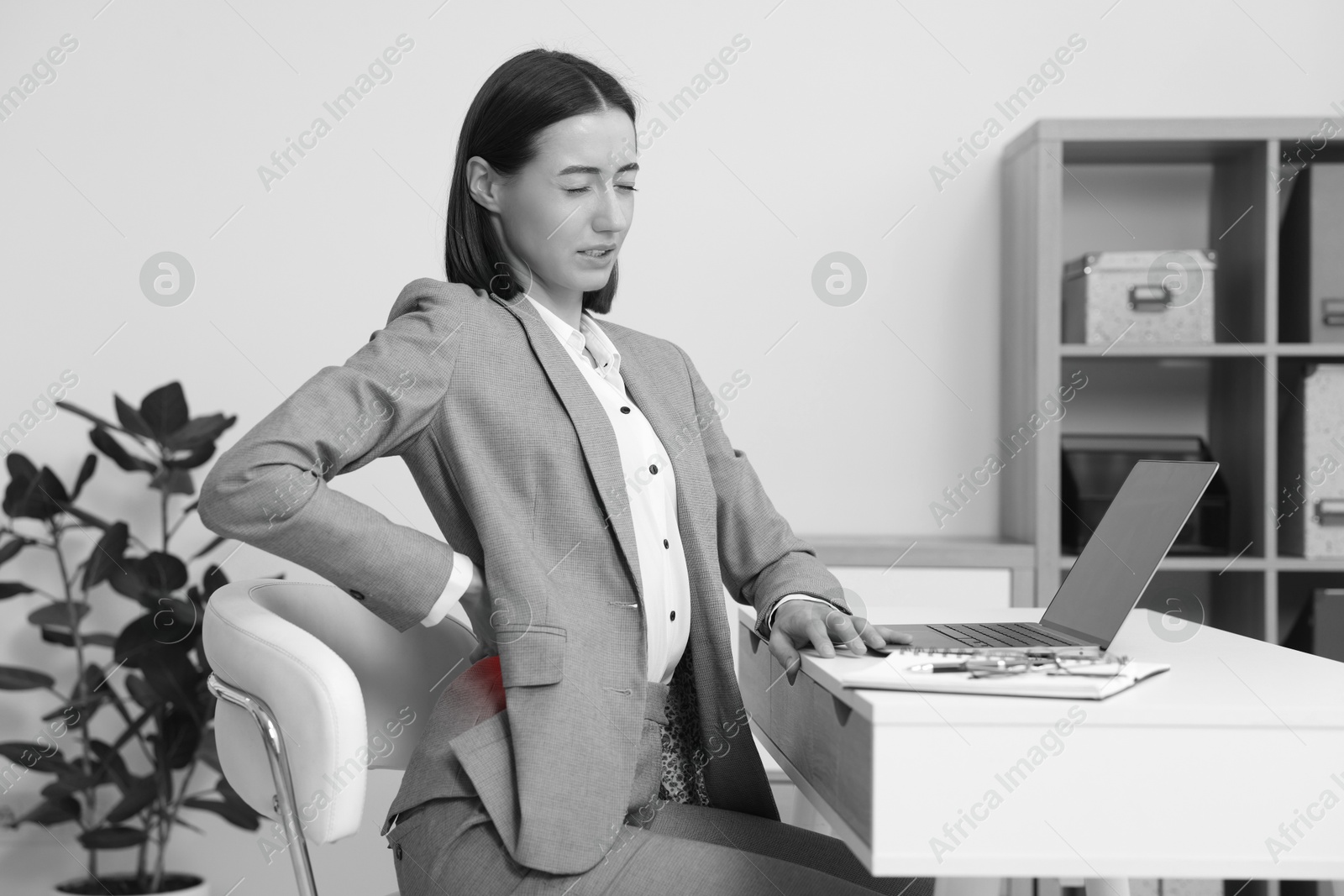 Image of Woman suffering from backache due to poor posture at workplace