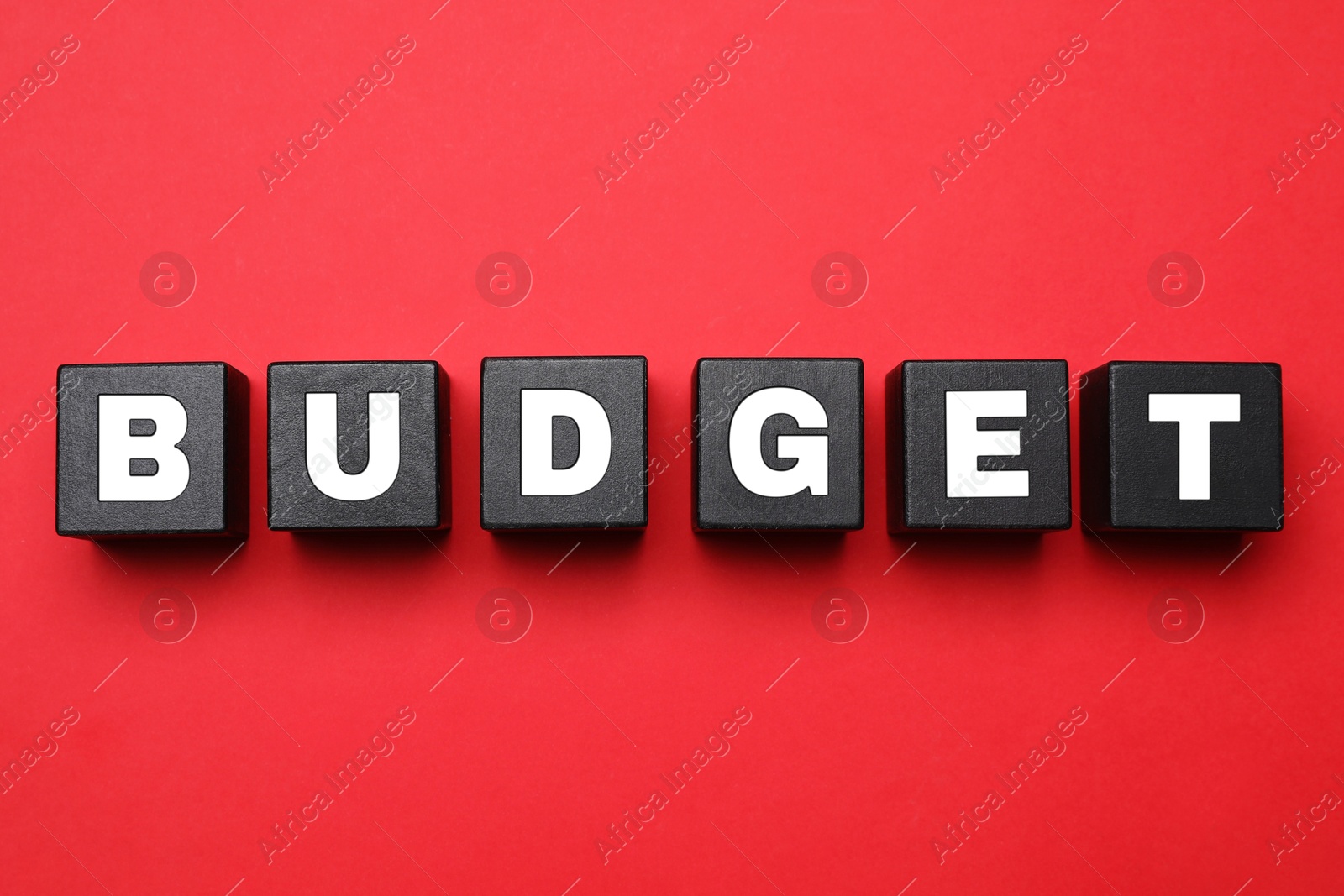 Image of Word Budget made of black cubes with letters on red background, top view