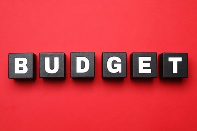 Image of Word Budget made of black cubes with letters on red background, top view