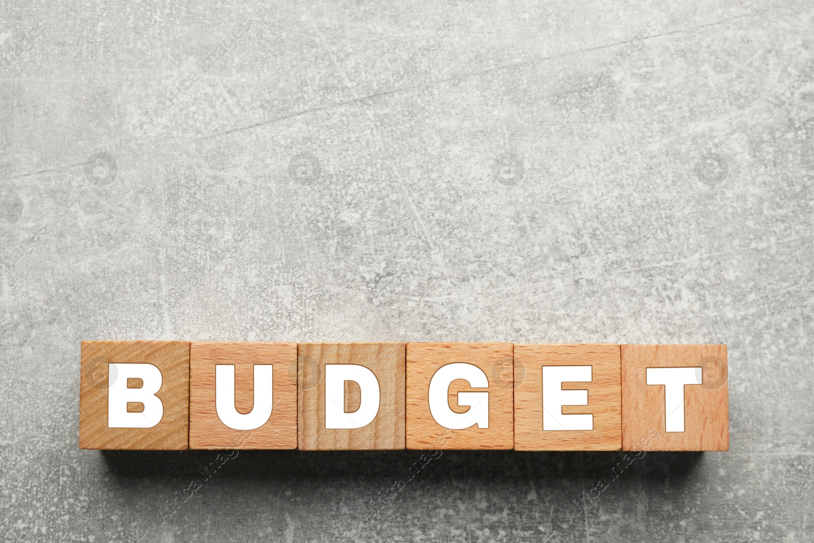 Image of Word Budget made of wooden cubes with letters on grey background, top view