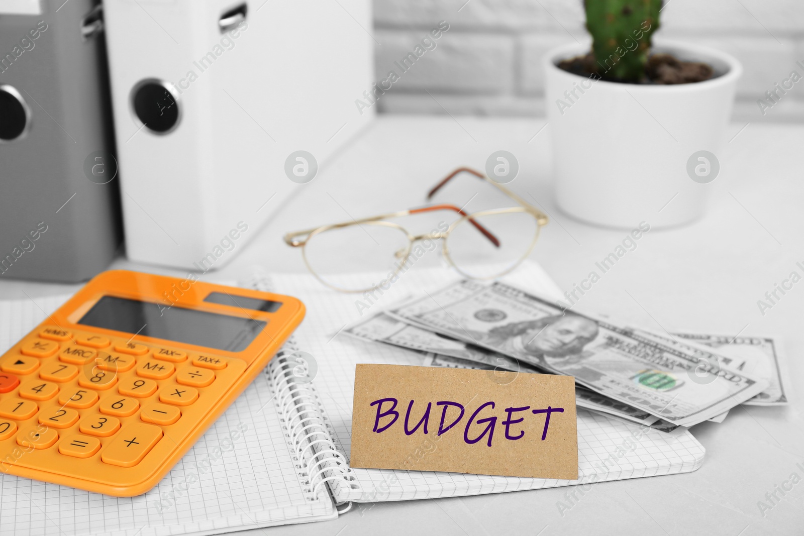 Image of Card with word Budget, calculator, glasses and money on white table